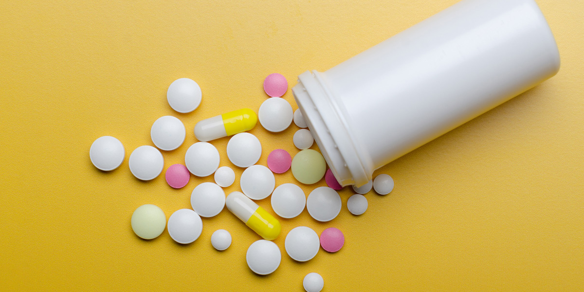 Scattered-opioid-pills-on-a-yellow-background