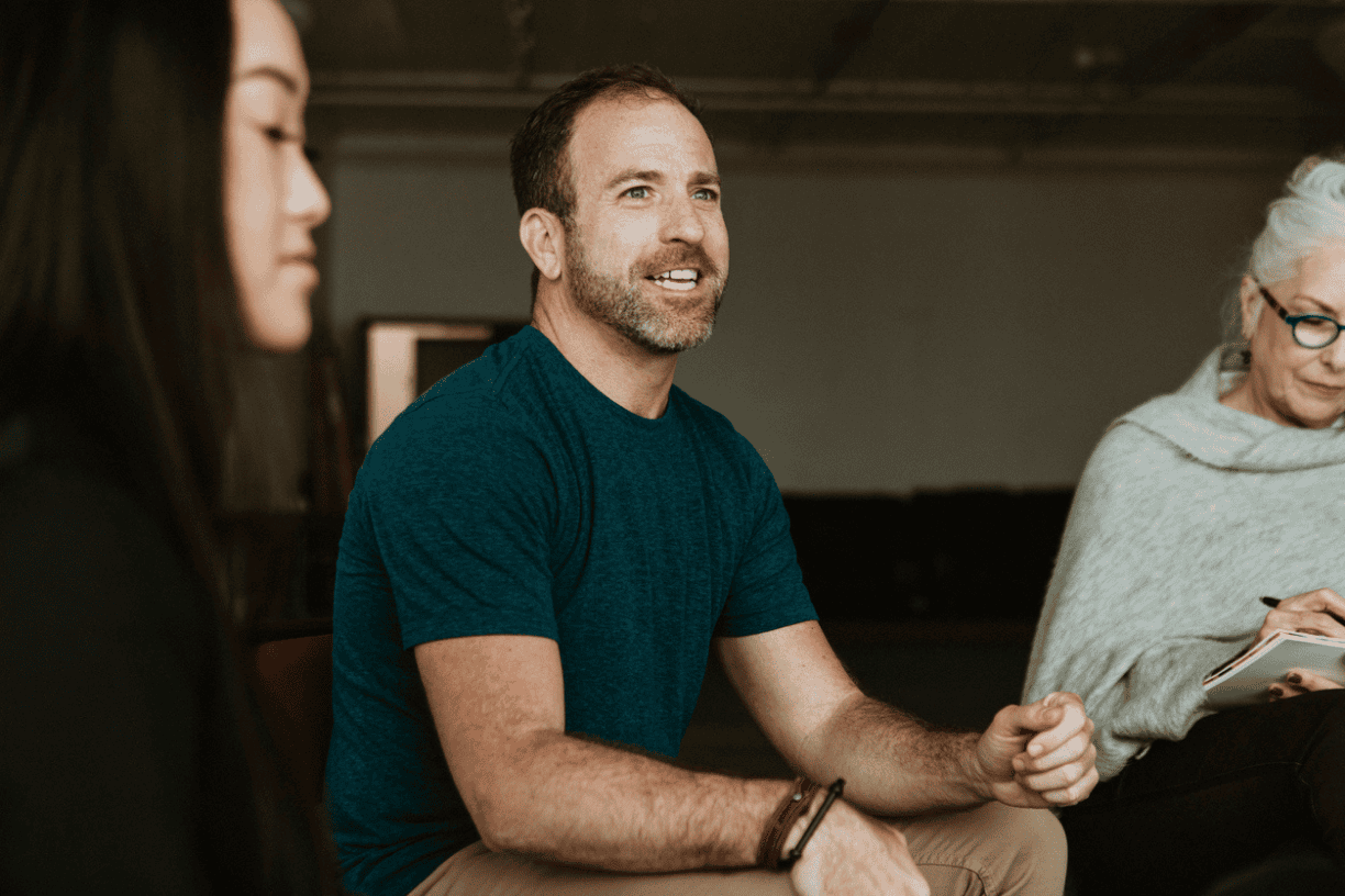 man speaking during a group therapy session while others listen