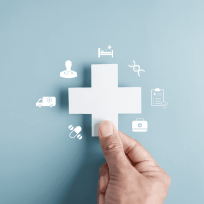 hand placing the final puzzle piece into a medical cross