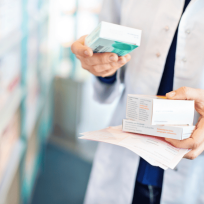 pharmacist standing in aisle holding prescriptions